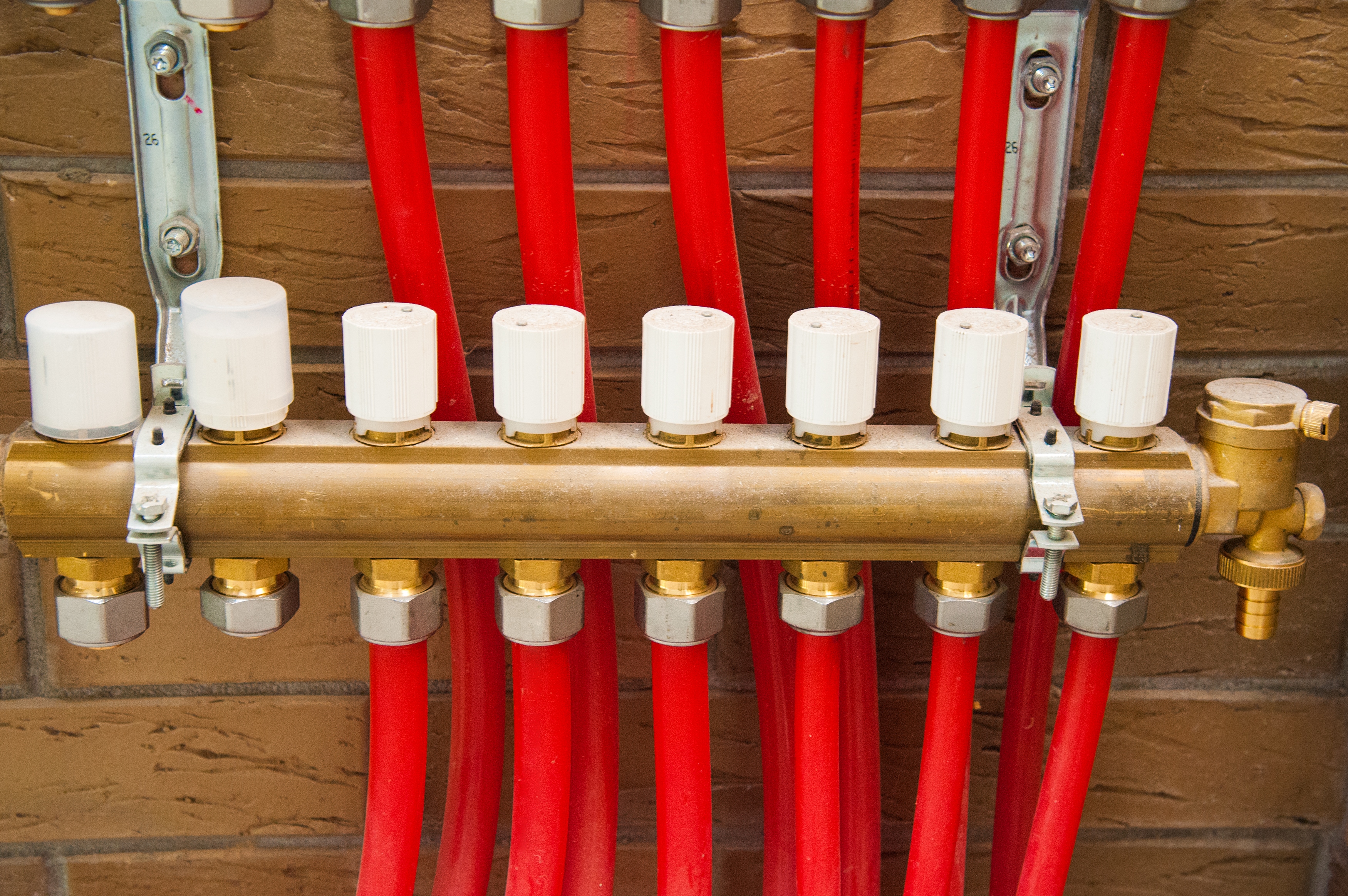 Heating system with red pipes and brass fixtures